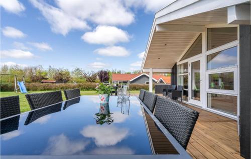 a patio with a table and chairs and a house at Holiday Home Strandparken Xi in Otterup