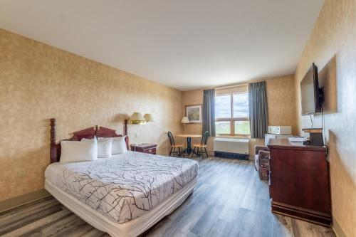 una camera d'albergo con letto e scrivania di Pilgrim Inn a Caronport