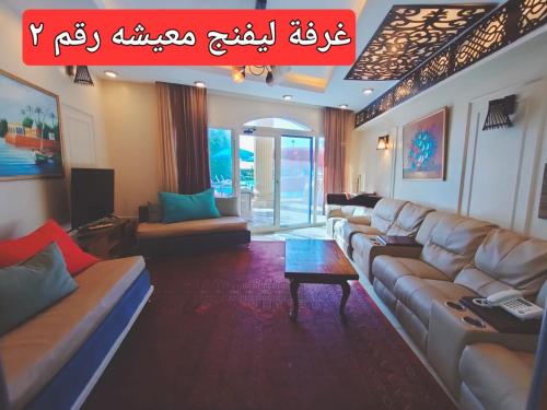 a living room with couches and a table in a room at Resort altayar Villa altayar 1 Aqua Park with Sea View in Sidi Krir 