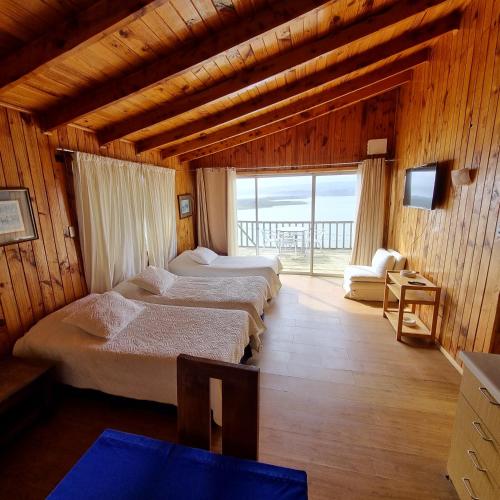 a bedroom with three beds in a room with a window at Max & Mar Pichilemu in Pichilemu