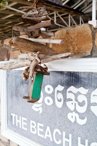 a sign for a beach house with a green candle at The Beach House in Kep