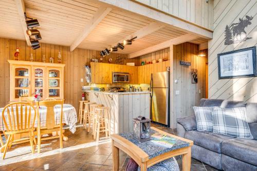 a kitchen and living room with a couch and a table at 0 5 Mi to Dtwn and Trails Conway Condo with Hot Tub! in North Conway
