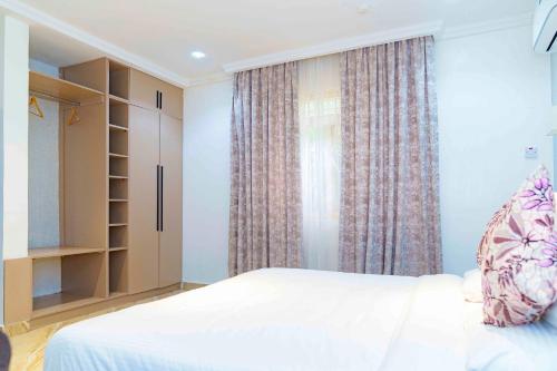 a bedroom with a white bed and a window at Aurora Smart Residence, Wuse 2, Abuja in Abuja