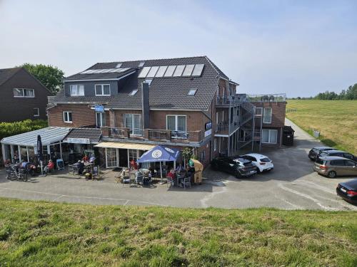 een gebouw met auto's geparkeerd op een parkeerplaats bij NordseeResort Hotel & Suite Arche Noah in Horumersiel