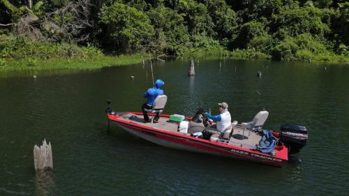 two people on a red boat in the water at Bungalu Fishing Lodge Panama in Colón