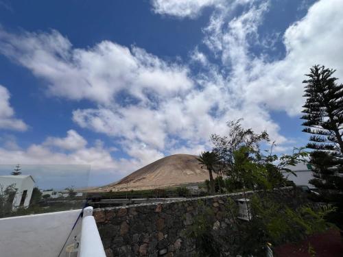 a mound of dirt with a blue sky and clouds at Casa Carla in La Vegueta