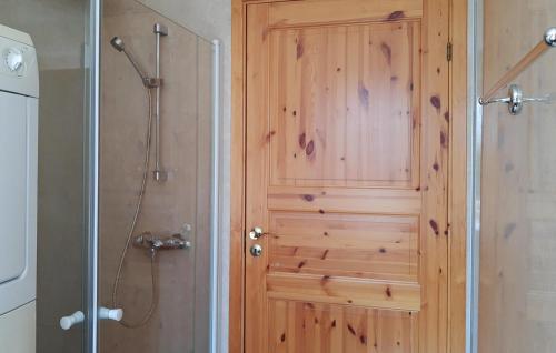 a wooden door in a bathroom with a shower at Lovely Home In Risør With Sauna in Risør