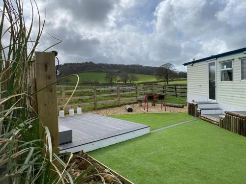 a backyard with a house and a green lawn at Duncliffe View - Shaftesbury North Dorset in Motcombe