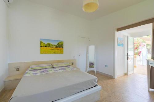 una camera bianca con un letto in una stanza di Casetta Margherita a Otranto