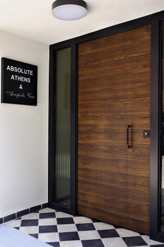 a wooden door in a room with a checkered floor at Absolute Athens Acropolis View in Athens