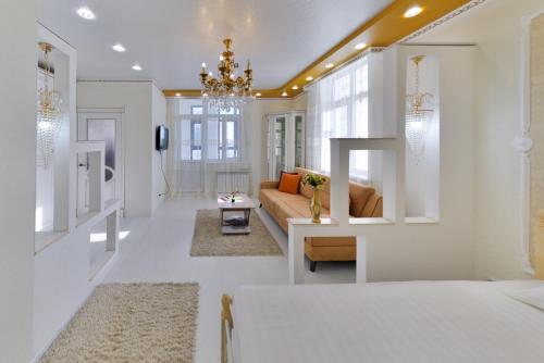 een woonkamer met een bank en een kroonluchter bij Однокомнатные апартаменты на Мангилик ел 51 in Astana