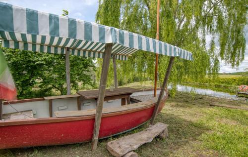 a small red boat with an umbrella on the grass at Gorgeous Home In Farnese in Farnese