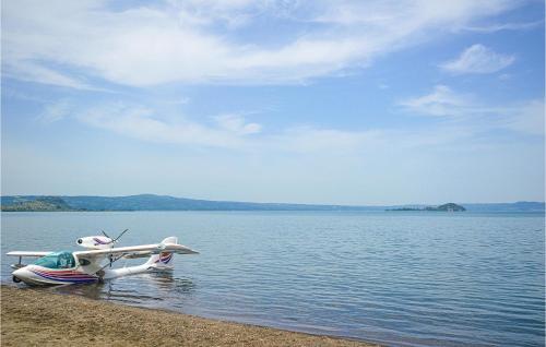 a small plane sitting on the shore of a lake at Gorgeous Home In Farnese in Farnese