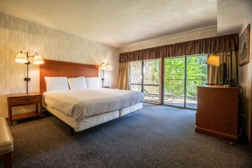 a hotel room with a bed and a large window at Sweetwater at Lake Conroe, a VRI resort in Montgomery