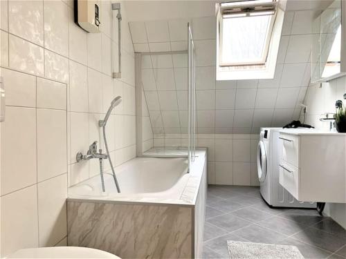 a bathroom with a tub and a washing machine at Uni-Klinikum- zentrale Lage von Holsterhausen in Essen