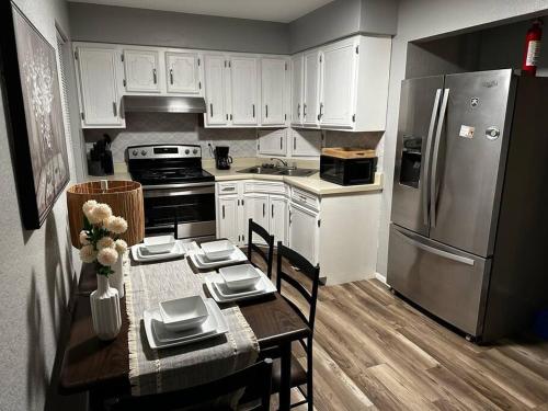 - une cuisine avec des placards blancs, une table et un réfrigérateur dans l'établissement Modern Stay 7, à Eagle Pass