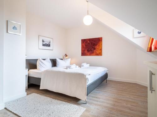 een witte slaapkamer met een bed en een trap bij Dünenhof DÜNENHOF Whg. D-11 in Wustrow