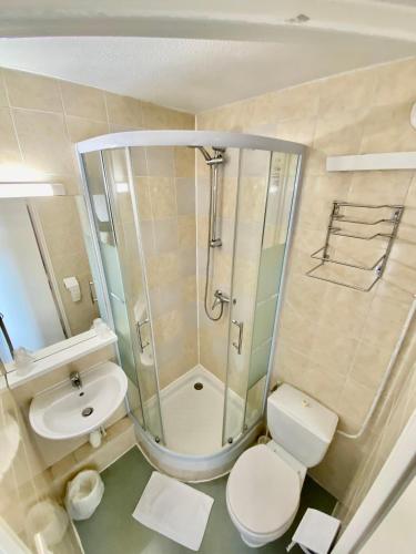 une salle de bain avec une douche, des toilettes et un lavabo dans l'établissement L'Escale d'Alès HOTEL, à Alès