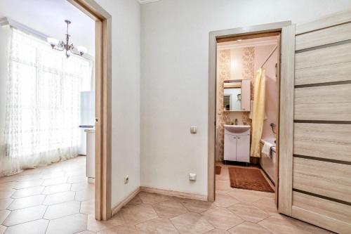 łazienka z drzwiami otwieranymi na łazienkę z umywalką w obiekcie Однокомнатные апартаменты на Мангилик ел 51 w mieście Astana