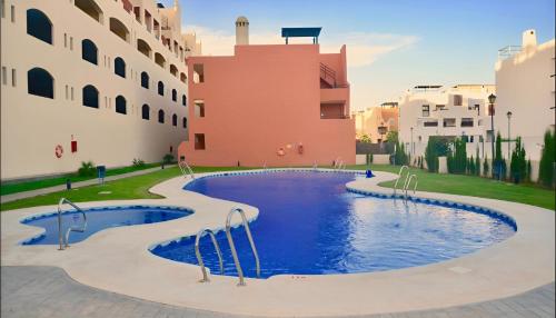 una gran piscina en medio de un edificio en Hestía Vera Mar Tu hogar de playa lejos de casa, en Vera