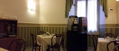 a dining room with a table and chairs and a refrigerator at Hotel Teti in Rome