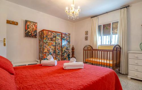 a bedroom with a red bed and a crib at Awesome Home In Alcala La Real in Alcalá la Real