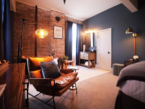 a bedroom with a bed and a chair and a desk at Historic Jacksonville Inn in Jacksonville