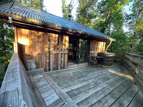 una cubierta de madera de una cabaña en el bosque en Treehouse Family en Ořešín