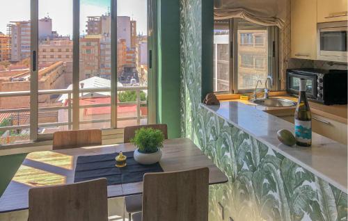 Una cocina con mesa y vista a una ciudad. en Awesome Apartment In Santa Pola, en Santa Pola