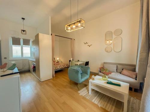 un salon avec un canapé et une table dans l'établissement Le moineau -Poterne -Parking gratuit -Calme-Centre, à Valenciennes