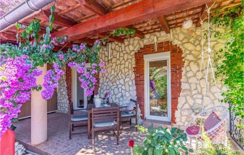 un patio con tavolo, sedie e fiori di 2 Bedroom Awesome Apartment In Medulin a Medulin
