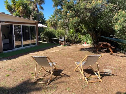 - deux chaises et une table de pique-nique dans la cour dans l'établissement Mini villa SANTA GIULIA, à Porto-Vecchio