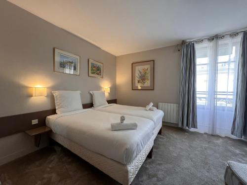 Postel nebo postele na pokoji v ubytování HÔTEL PARIS VÉSINET- Logis Hôtel Restaurant