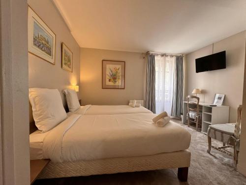 a bedroom with a large white bed and a window at HÔTEL PARIS VÉSINET- Logis Hôtel Restaurant in Le Vésinet
