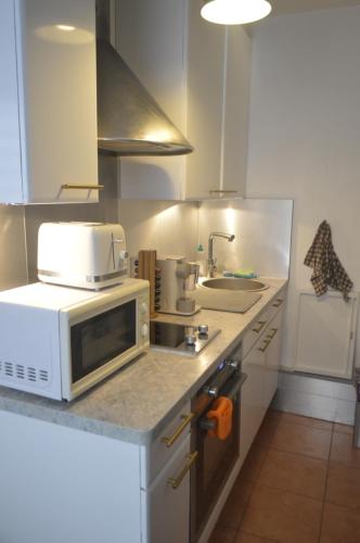 a kitchen with a microwave and a sink at Paris Ouest Appartment in Courbevoie