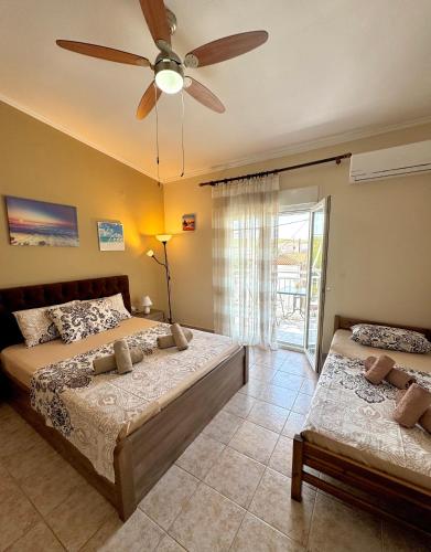 a bedroom with two beds and a ceiling fan at Theodora’s Studios in Repanídhion