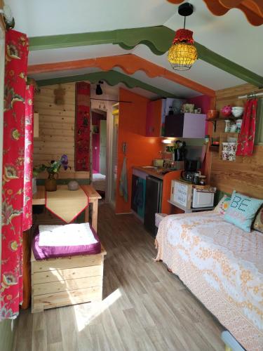 a bedroom with a bed and a kitchen in it at Graines de nature - Ecolodges Insolites in Saint-Eutrope-de-Born