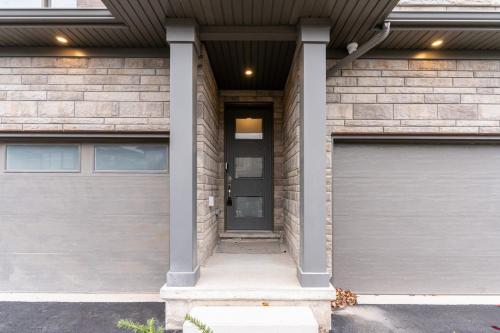 a house with two garage doors in front at Niagara Falls Luxury Living - 8 GUEST HOUSE in Niagara Falls