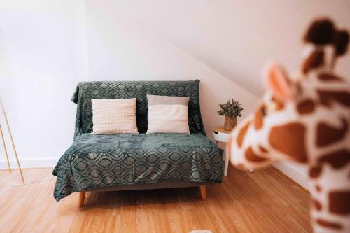 - un canapé vert avec deux oreillers dans l'établissement Le Chaleureux • Lumineux • Stationnement Facile, à Déols