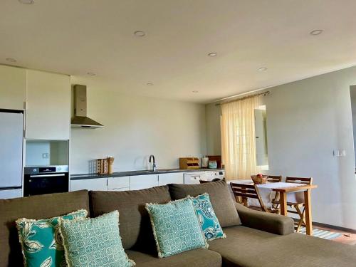 a living room with a couch and a kitchen at Quinta da Nasce Água in Angra do Heroísmo