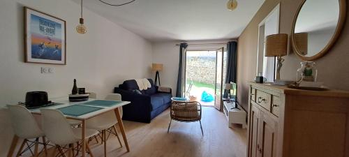 un salon avec une table et un canapé bleu dans l'établissement Centre du Val André - appart en rez de jardin avec terrasse et jardinet - plage à 150 m, à Pléneuf-Val-André