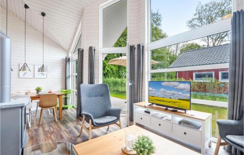 ein Wohnzimmer mit einem TV und einem Tisch mit Stühlen in der Unterkunft Lovely Home In Krems Iiwarderbrück in Göls