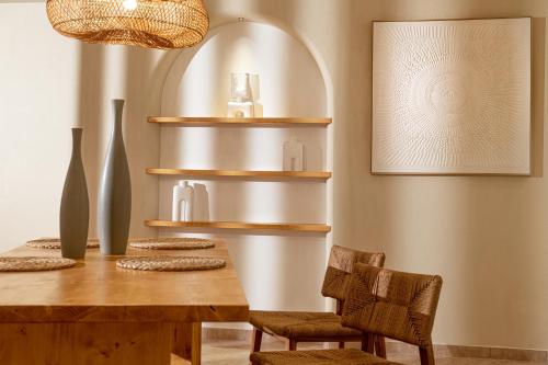Elea Suites & Residences في غوفي: غرفة طعام مع طاولة وكراسي خشبية
