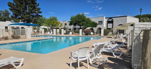 a swimming pool with chairs and an umbrella at Refreshing POOL Old Town Scottsdale 4 Bdr 3 FULL Baths in Scottsdale
