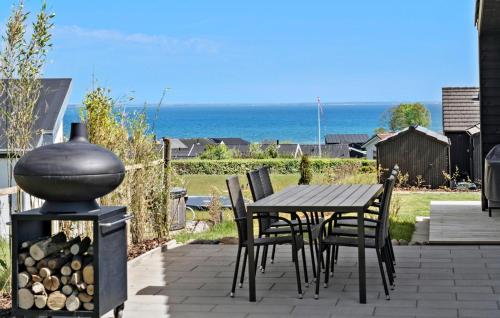 a patio with a table and chairs and the ocean at 4 Bedroom Stunning Home In Sjølund in Sjølund