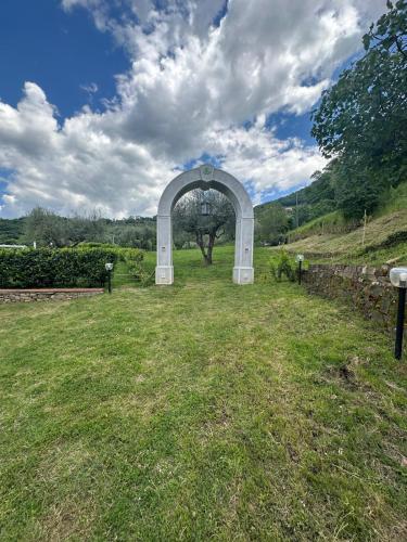 an arch in the middle of a grass field at Agri Resort Masusa in Aquara