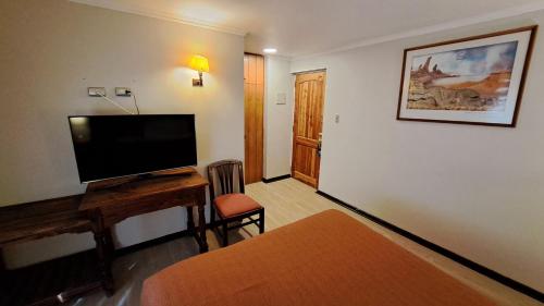 a living room with a flat screen tv on a desk at Hotel Diego de Almagro San Pedro De Atacama in San Pedro de Atacama