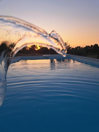 una persona está vertiendo agua en una piscina en Monte do Rochinha, en Monte da Cardosa