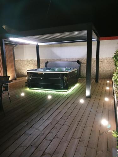 a patio with a pool table on a deck at night at Gite avec Spa Le Rubis proche des plages du Débarquement Manche Normandie in Joganville