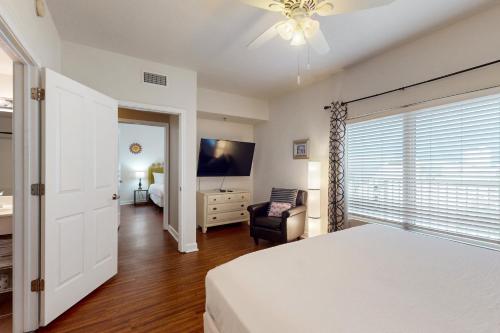 a bedroom with a bed and a chair and a television at Shores of Panama 1507 in Panama City Beach